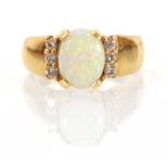 An 18ct yellow gold ring set oval opal and six small diamonds,ring size O,5.6 gms