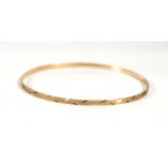 A 9ct yellow gold engraved bangle, d. 6.5 cm, 3.4 gmsSlightly mis-shapened
