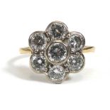 An 18ct yellow gold ring set seven brilliant cut diamonds in a flowerhead setting,central stone
