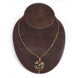 An 18ct yellow gold flat curblink necklace suspending a 9ct openwork pendant set turquoise in the