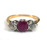 A yellow metal ring set round cut ruby and two old brilliant cut diamonds in an inline setting,