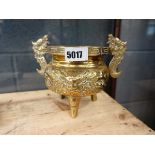 A Chinese brass censer relief decorated with a mask below a pair of applied handles, on three