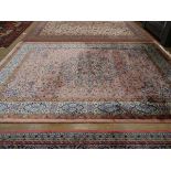 A Pakistani wool carpet with a pale pink ground, 350 x 250 cm