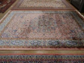 A Pakistani wool carpet with a pale pink ground, 350 x 250 cm