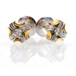 A pair of yellow and white metal ear studs, each set a small brilliant cut diamond within a cross
