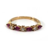 A 9ct yellow gold half eternity ring set four small marquise shaped rubies interspersed with three