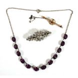 An Edwardian yellow metal bar brooch, w. 4.8 cm, 2.7 gms, a silver mounted purple glass necklace and