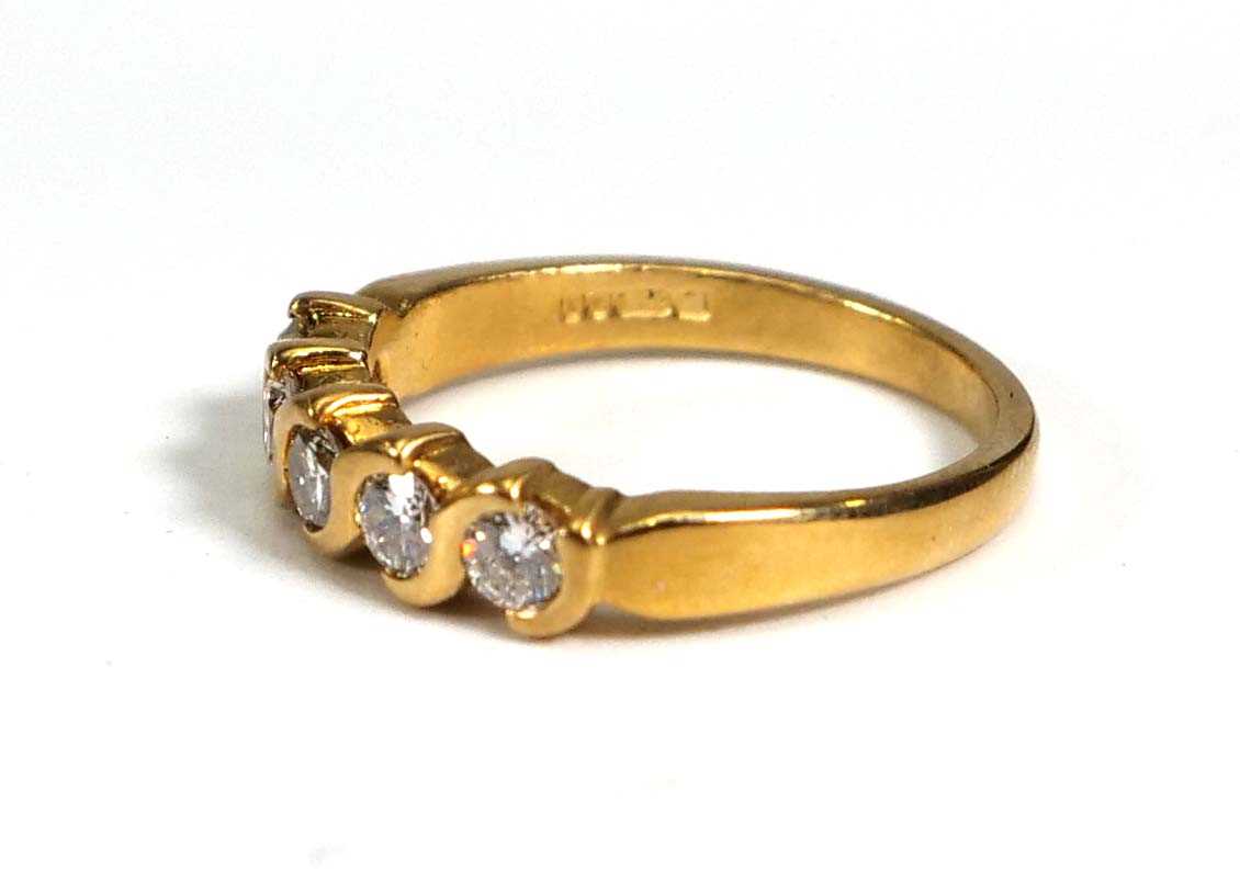 An 18ct yellow gold ring set five brilliant cut diamonds in s-shaped rubover settings,total - Bild 2 aus 4