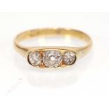 An 18ct yellow gold ring set three graduated old cushion cut diamonds in an oval mount, central