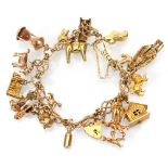 A 9ct yellow gold fancy link bracelet with heart shaped padlock clasp suspending sixteen 9ct and