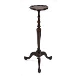 A 19th century walnut wine table, the floral moulded surface on a turned tapering column and three