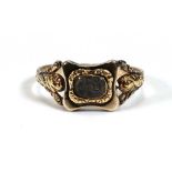 A 19th century yellow metal mourning ring with plaited hair section within a scrolled setting,ring