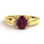 An 18ct yellow gold ring set oval ruby and six small diamonds, ring size L, 2.8 gms