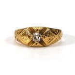 A late 19th century yellow metal ring set old cushion cut diamond in an engraved four claw setting,