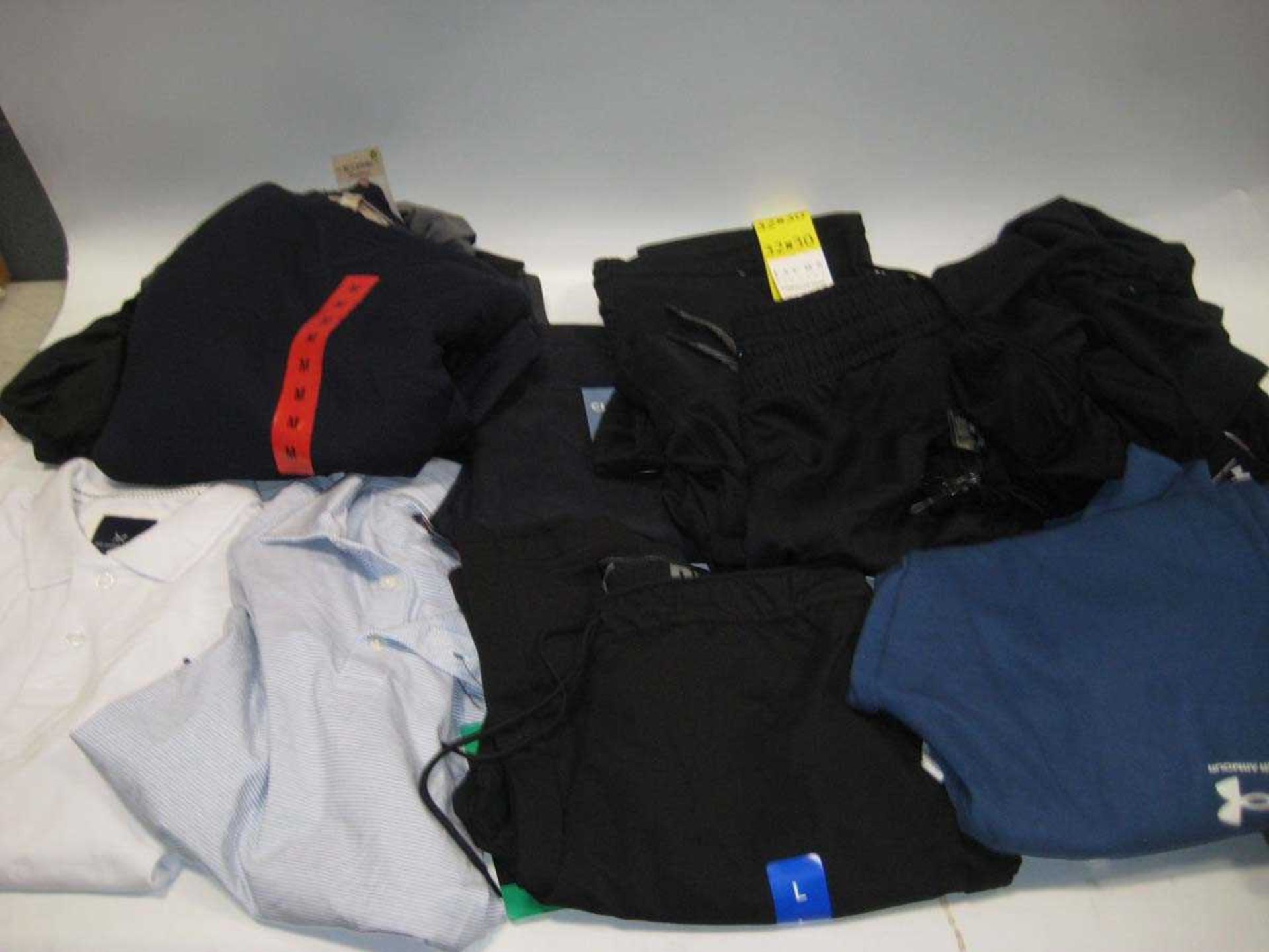 +VAT A bag containing Men's clothing in various styles and sizes, including Under Armour, Puma.