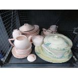 Cage containing pink glazed and floral patterned crockery