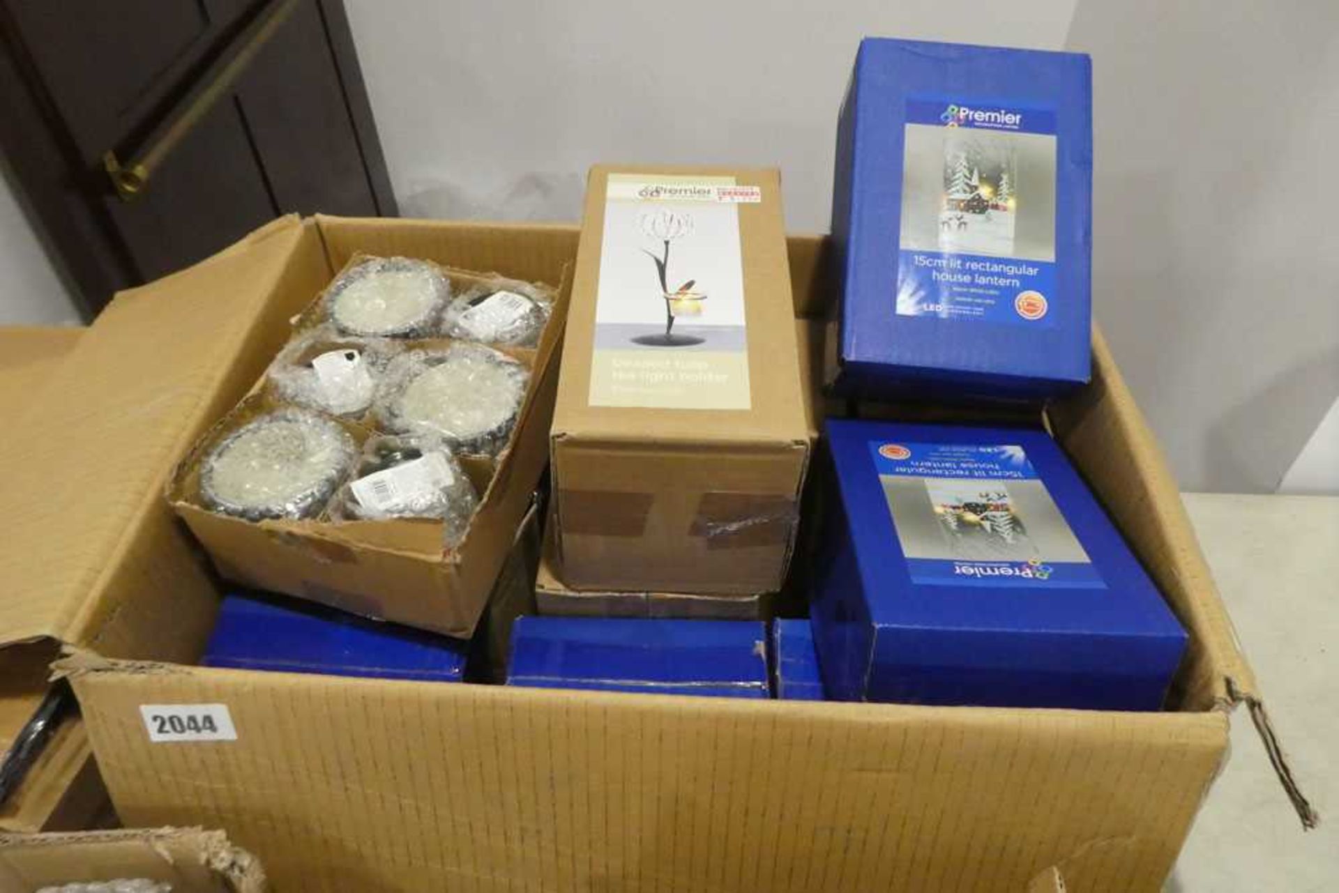 A box of various tea light holders and lanterns.