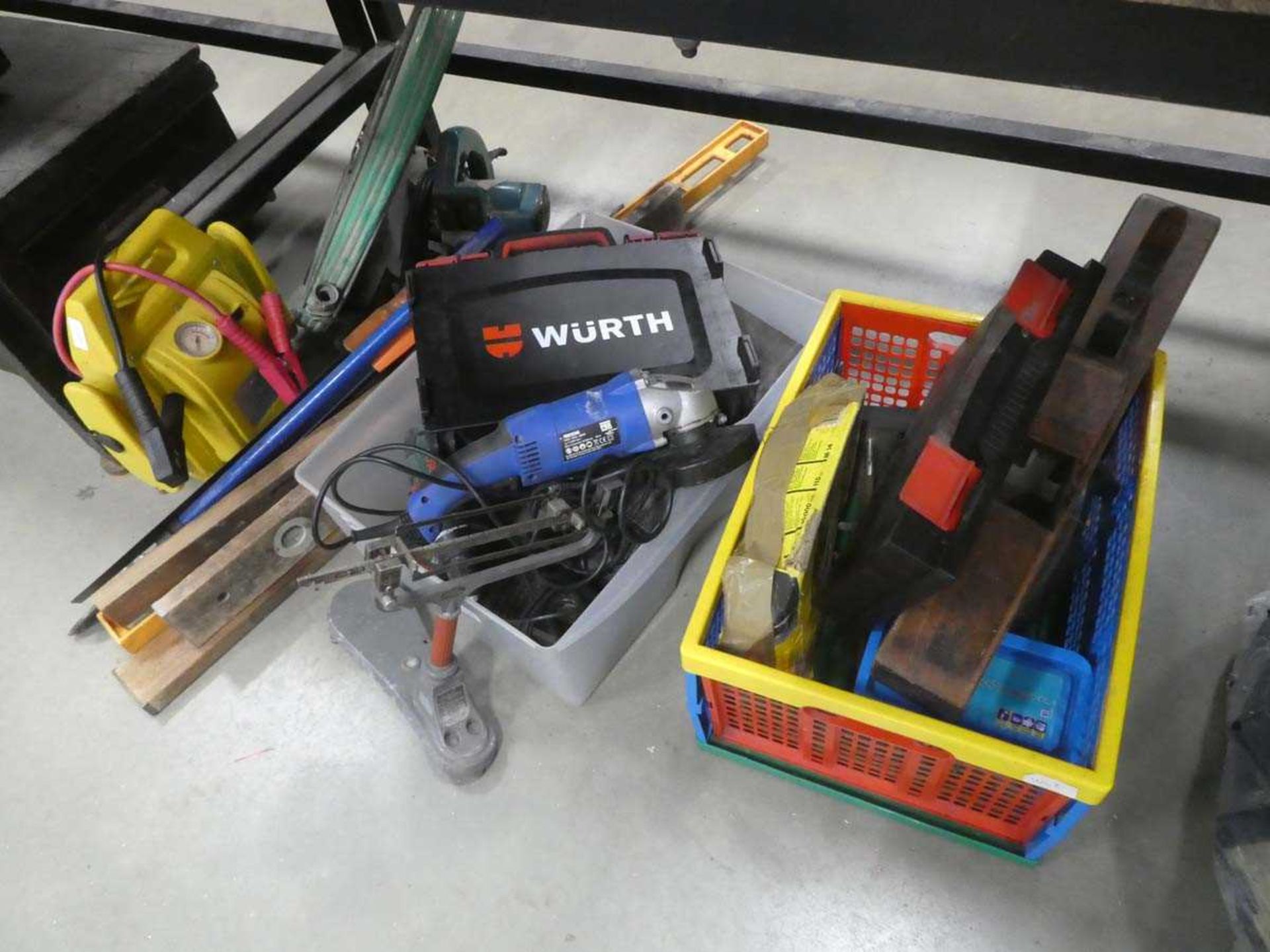 3/4 of an under bay of assorted tools including jump start kit, drills, grinders, hose, saws etc