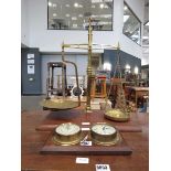 Wall mounted barometer and a set of brass scales on wooden plinth