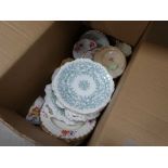 Box containing floral and leaf patterned crockery