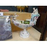 A Meissen style figural table centre of urn shaped form decorated with figures riding a serpent,