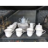 Cage containing a silver rimmed tea service