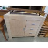 Lime washed cabinet with single door and three drawers to the side