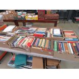 Tabletop with 9 boxes of various reference books and novels