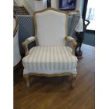 Beige upholstered open armchair with limed wooden frame