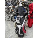 Vogue branded golf bag containing a quantity of Vogue golf clubs on trolley
