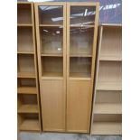 Light oak effect two door glass fronted bookcase with a similar five shelf bookcase