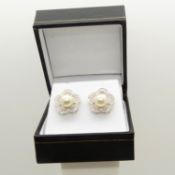 An 18ct white gold daisy-style pearl and diamond halo ear studs, boxed