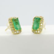 An attractive pair of 18ct yellow gold step-cut emerald and diamond halo stud earrings, boxed