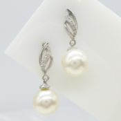 A pair of flame-style cultured pearl and diamond drop earrings in 9ct white gold