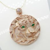 A large rose gold-coated circular tiger pendant set with green accents and white cubic zirconia