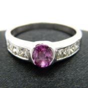 Oval pink sapphire ring with princess-cut diamond shoulders