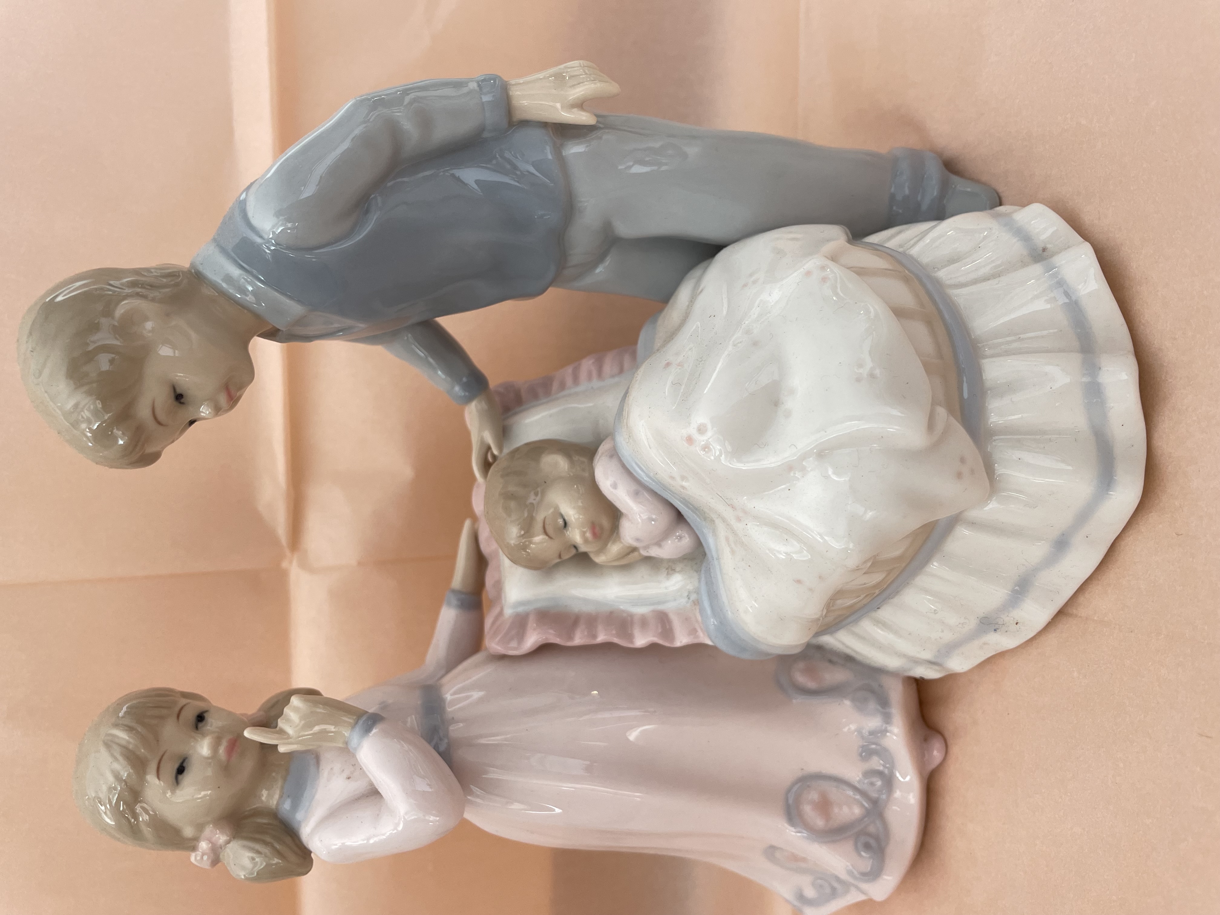 Mother and father watching a baby sleeping - figurine