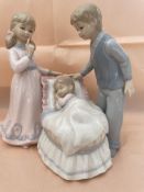 Mother and father watching a baby sleeping - figurine