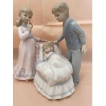 Mother and father watching a baby sleeping - figurine