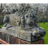 A PAIR OF RECUMBENT STONE LIONS, reconstituted stone. 71cm x 34cm