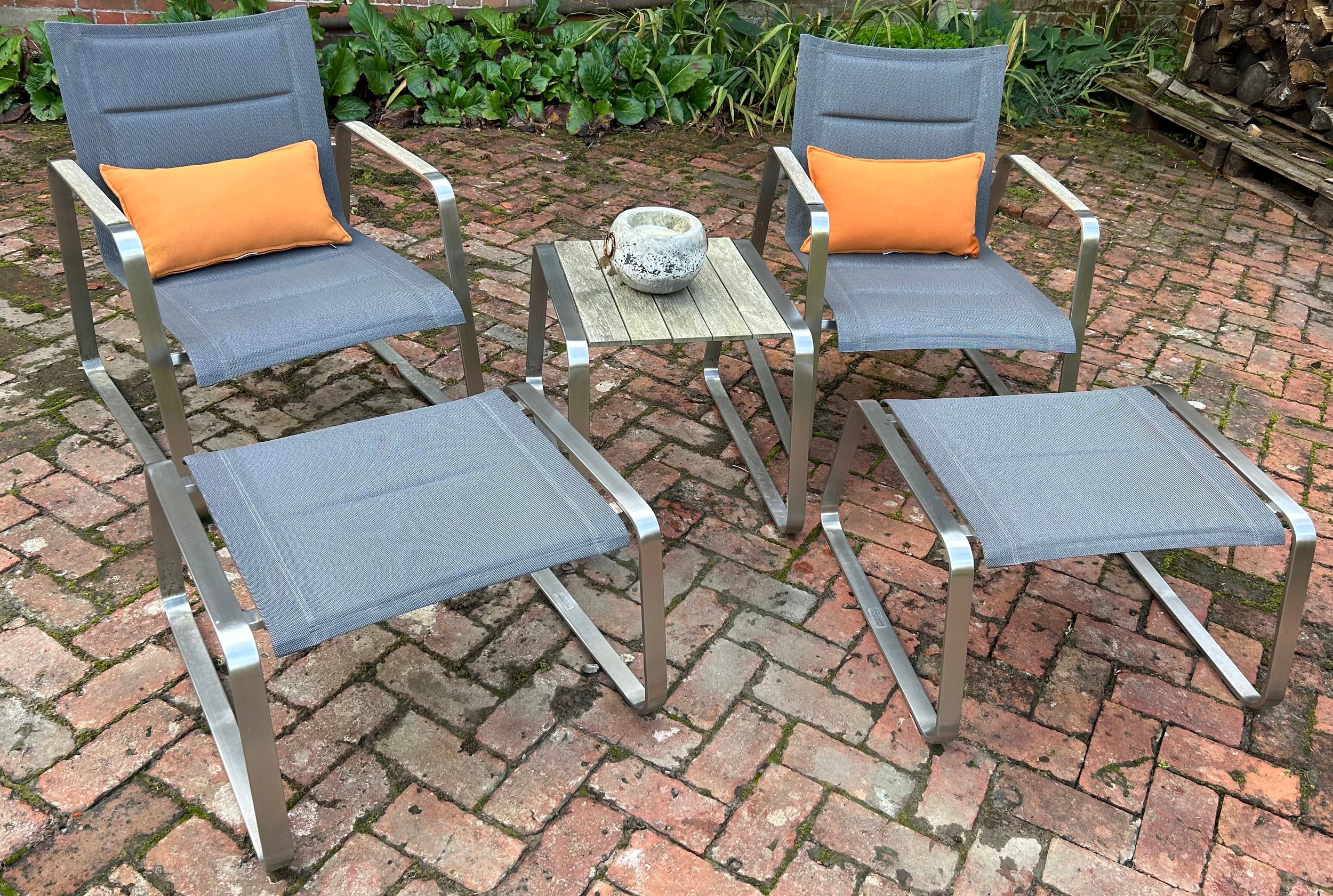 AN INDIAN OCEAN COURTYARD LOUNGE SET, consisting of two chairs, footstools and side table. All