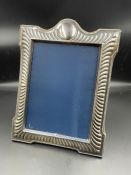 A silver photo frame, by Carr's of Sheffield 1993 hallmark. (28cm x 23cm)