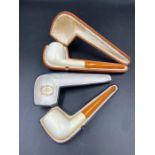 Two antique pipes with amber style stems.