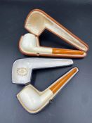 Two antique pipes with amber style stems.