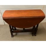 A drop leaf gate leg table with drawer to one end