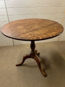 A light oak tilt top table on triform legs