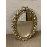 An oval mirror with carved foliage surround (80cm x 55cm)