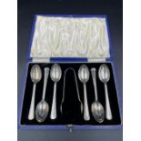 A cased set of six silver teaspoons and sugar nips, hallmarked for Birmingham 1935 by Elkington &
