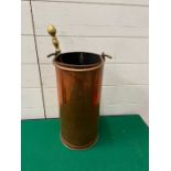 A copper coal bucket with brass poker