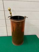 A copper coal bucket with brass poker